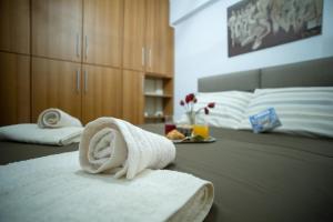 una habitación de hotel con una toalla en una cama en At Aqua Apartment Athens, en Atenas