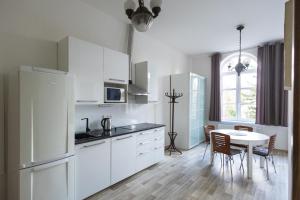 a kitchen with white cabinets and a table with chairs at Apartmány U Davídků in Cerny Dul