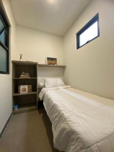a small bedroom with a bed and a window at Mely’s Tiny Home in Samporo