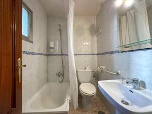 y baño con bañera, aseo y lavamanos. en Pensión Recogidas, en Granada