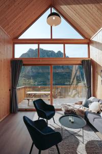 a living room with a couch and chairs and a large window at Lofoten Cabins in Hopen