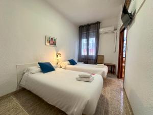 Habitación de hotel con 2 camas y almohadas azules en Pensión Recogidas, en Granada