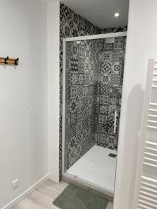 y baño con ducha y pared de azulejos. en T3 en duplex logement entier, en Charlieu