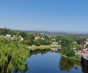 una vista de un río con una ciudad en el fondo en FRANCISMAR - Cálido Depto. Centro Carlos Paz en Villa Carlos Paz