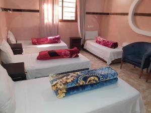 Zimmer mit 3 Betten und einem blauen Stuhl in der Unterkunft IMLIL VALLEY Garden in Imlil