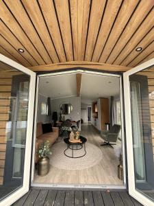 un porche cubierto con techo de madera en Luxe Bos Cottage SERENDIPITY, en Beekbergen