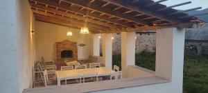 a patio with a table and chairs and a fireplace at Hovit Holiday Home in Margahovit