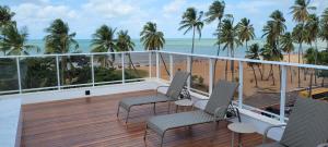 uma varanda com cadeiras e vista para a praia em Aconchegante Apartamento Beira-Mar (Ampla Varanda) em João Pessoa