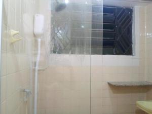 a bathroom with a glass shower with a window at Ninho do pelicano in Fortaleza
