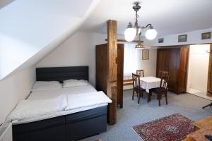 a bedroom with a bed and a table and chairs at Apartmány U Davídků in Cerny Dul
