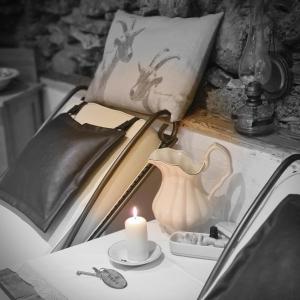 Una vela sentada sobre una cama con un libro en Haus Edelweiss - Ferienhaus, en Spiss