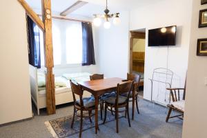 a dining room with a table and chairs and a bed at Apartmány U Davídků in Cerny Dul