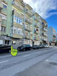 a street with cars parked in front of a building at Ambientes do Rio Home in Sacavém