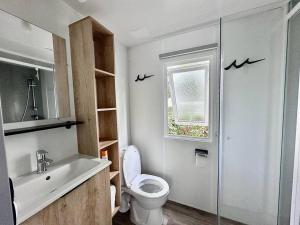 baño con aseo y lavabo y ventana en 381 Emplacement prestige à la Réserve 4*, en Gastes