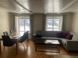 a living room with a couch and a table at Hafjell Farmhouse in Øyer