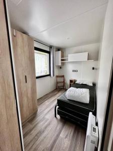 Habitación pequeña con cama y puerta en 381 Emplacement prestige à la Réserve 4*, en Gastes