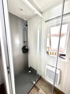 baño con ducha y puerta de cristal en 381 Emplacement prestige à la Réserve 4*, en Gastes