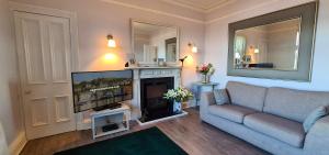 a living room with a couch and a tv and a fireplace at Three Oban in Oban