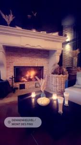 a living room with a fireplace and a table with candles at Mont-Des-Pins Domaine de Vacances, Vakantiedomein Dennenheuvel in Durbuy