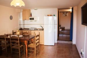 a kitchen with a table and a white refrigerator at Casa rural El Cestero in Castellote