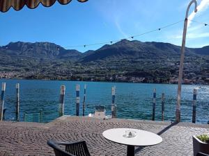 a table and chairs sitting next to a body of water at Open space fronte lago in Monte Isola