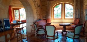 Saint-CybranetにあるMaison de 4 chambres avec piscine partagee et jardin amenage a Saint Cybranetの椅子とテーブル、窓が備わる客室です。