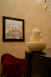 uma tigela de conchas numa mesa com uma cadeira vermelha em Lo Stemma Luxury Boutique Hotel em Matera