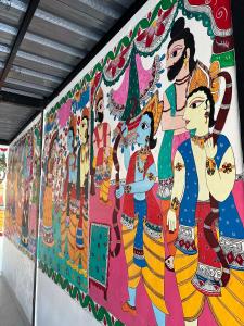 een muurschildering van een groep mensen op een muur bij Mithila Thali By Chef Santosh Shah in Janakpur