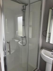 a bathroom with a shower and a sink at Perranporth Holiday Park in Perranporth