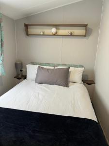 a bedroom with a bed with white sheets and pillows at Perranporth Holiday Park in Perranporth