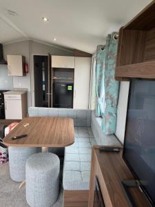 a living room with a dining table and a kitchen at Perranporth Holiday Park in Perranporth