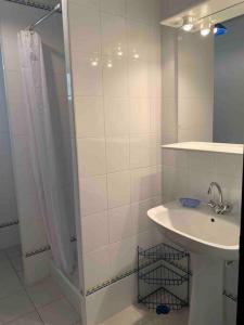 y baño blanco con lavabo y ducha. en Gîte 45 m2 3/4 personnes, en Bessèges