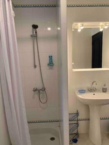 baño blanco con ducha y lavamanos en Gîte 45 m2 3/4 personnes, en Bessèges