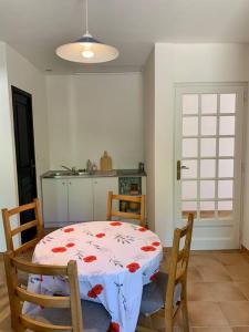 comedor con mesa y sillas y cocina en Gîte 45 m2 3/4 personnes, en Bessèges
