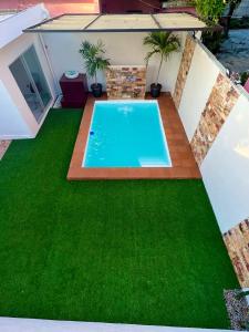 un patio trasero con piscina y césped verde en La casa del profe, en Tampico