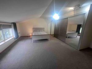 ein leeres Zimmer mit einem Bett und einem Spiegel in der Unterkunft Kensington Apartments in Newhouse