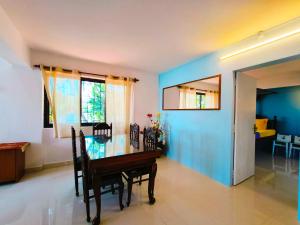 a dining room with a table and a blue wall at Entire River Villa in Canacona