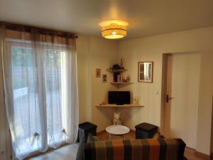 a living room with a table and a large window at L'appentis in Bligny-lès-Beaune
