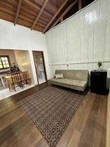 sala de estar con sofá y alfombra en Vila dos pássaros, Quarto 03 en Itapema