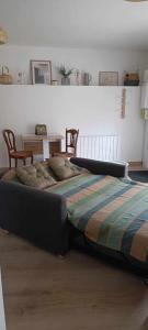 1 cama en un dormitorio con mesa y sillas en L'appentis en Bligny-lès-Beaune