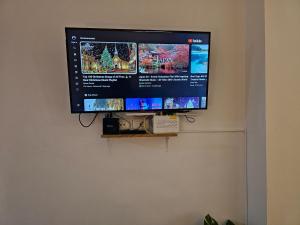 einen Flachbild-TV, der an einer Wand hängt in der Unterkunft Vibe Studio Apartment in Tirana