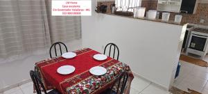 a red table with plates on it in a kitchen at LM Home 1 - casa com 2 quartos in Governador Valadares