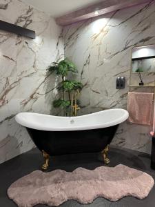 y baño con bañera y planta. en Habitación LUXURY LOVE, en Sant Carles de la Ràpita