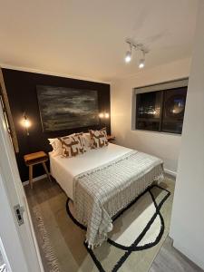 ein Schlafzimmer mit einem Bett und zwei Fenstern in der Unterkunft Castle Rock Apartment in Kapstadt