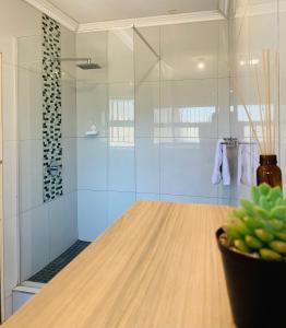 bagno con doccia e tavolo in legno di Edladleni Holiday Accomodation a Durban Altre 28 foto