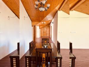 Divine Hills Mashobra في شيملا: غرفة طعام مع طاولة طويلة وثريا