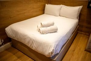 a bed with two towels on top of it at Berkley Apartments in London