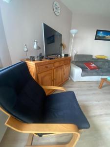 a living room with a chair and a couch at Appartement T3 - 4 personnes - Face Océan - Thalasso in Pornichet