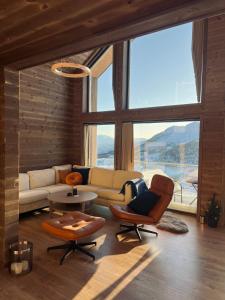 a living room with a couch and a table and chairs at Rindabotten Panorama in Sogndal