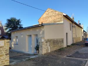 una pequeña casa blanca con un ladrillo en L'appentis en Bligny-lès-Beaune